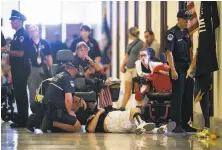  ?? Al Drago / New York Times ?? Police remove protesters staging a “die-in” outside Senate Majority Leader Mitch McConnell’s office Thursday.