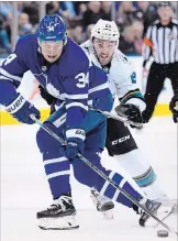  ?? NATHAN DENETTE THE CANADIAN PRESS ?? San Jose Sharks’ Barclay Goodrow, right, picks up a holding penalty on Maple Leafs’ Auston Matthews in the first period. The Leafs won, 5-3, with Matthews collecting two goals and an assist.