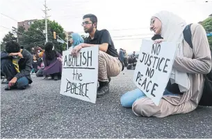  ?? STEVE RUSSELL TORONTO STAR ?? Protesters pause for a moment of silence during a vigil Monday near the Malton apartment building where 62-year-old Ejaz Choudry was fatally shot by Peel police officers Saturday.