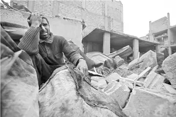  ??  ?? A Syrian man mourns over his destroyed home in the rebel-held besieged town of Arbin. — AFP photo