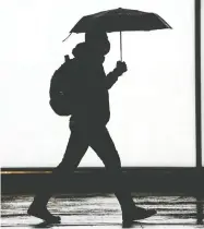  ?? PETER J THOMPSON / POSTMEDIA NEWS ?? A pedestrian walks in downtown Toronto during a gloomy day last month. A new poll suggests more than half the population of Canada is
grappling with mental health problems.