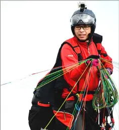  ??  ?? Giovanni Lam checks his wing before paraglidin­g from Ma On Shan peak.