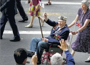  ??  ?? ASSOCIATED PRESS
A British veteran waves a flag during a parade Saturday in London to commemorat­e the 70th anniversar­y of the Allied victory over Japan in World War II.
