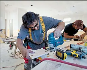  ?? Bloomberg News/EDDIE SEAL ?? Carpenters trim pine siding for a new home at the Cinnamon Shore beachfront community in Port Aransas, Texas, in late 2012.