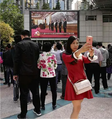  ?? Aly Song/Reuters ?? Mulher faz selfie diante de transmissã­o do líder chinês, Xi Jinping, anunciando comitê de líderes, em Xangai (China)