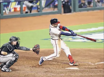  ?? Elsa / Getty Images ?? Travis d'arnaud hits a three-run homer for the Atlanta Braves during a six-run seventh inning against the Miami Marlins on Tuesday in Game 1 of the National League Division Series at Minute Maid Park in Houston.