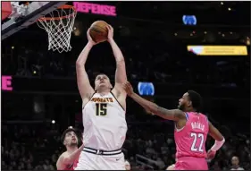  ?? CAROLYN KASTER — THE ASSOCIATED PRESS ?? Denver Nuggets center Nikola Jokic (15) grabs a rebound over Washington Wizards guard Monte Morris, right, and forward Deni Avdija during the second half Wednesday in Washington.