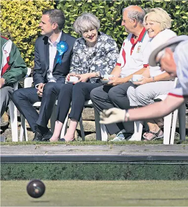  ??  ?? Rolling on: Theresa May at Atherley Bowling Club in Southampto­n yesterday, shortly after starting her day at 5.30am in Smithfield Market in London, right