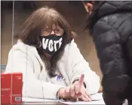  ?? Tyler Sizemore / Hearst Connecticu­t Media ?? Ballot clerk Marianne Lasalanbra assists a voter on Election Day 2020 at the District 5 polling center at Stamford High School in Stamford on Nov. 3.