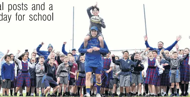  ?? PHOTO: PETER MCINTOSH ?? Achieving his goal (posts) . . . Josh Thompson (10), of St Bernadette's School, is carried on the shoulders of Otago midfielder Josh Timu in front of the school’s new rugby posts yesterday.