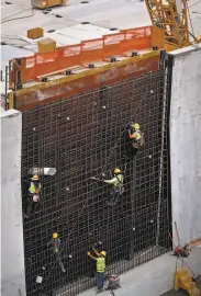  ?? Michael Macor / The Chronicle 2017 ?? Workers set rebar in the concrete forms to rebuild walls of the dam’s main spillway in October 2017.