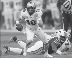  ?? The Associated Press ?? SLIPPING FREE: Central Florida quarterbac­k McKenzie Milton (10) runs out of the pocket against Auburn during the first half of the Peach Bowl Monday in Atlanta.