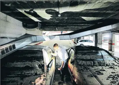  ?? ÀLEX GARCIA ?? Juan Antonio Gázquez, ayer, entre dos coches que resultaron afectados por la inundación de septiembre