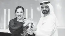  ?? JON GAMBRELL THE ASSOCIATED PRESS ?? British school teacher Andria Zafirakou accepts the Global Teacher Prize trophy from Dubai's ruler, Sheikh Mohammed bin Rashid Al Maktoum.