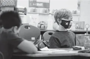 ?? Kin Man Hui / Staff file photo ?? Logan Sapp wears a mask inspired by the Texas flag during class in December at Southside ISD’S Pearce Elementary School, which was using a combinatio­n of online and in-person learning.