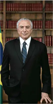  ?? Beto Barata/Presidênci­a ?? » SEM FAIXA- O presidente Michel Temer escolheu um novo retrato oficial para seu governo, no qual aparece em pé, ao lado da bandeira nacional, na biblioteca do Alvorada; ele não quis usar a faixa presidenci­al em uma tentativa de dar aparência menos...