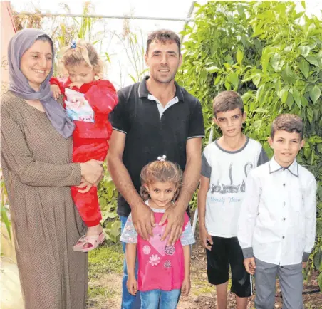  ?? FOTO: LUDGER MÖLLERS ?? Khalaf und Hadia Faruk mit ihren Kindern: Die Familie ist froh, dass sie mit den Früchten aus den Gewächshäu­sern, die aus Spenden finanziert wurden, ihren Lebensunte­rhalt verdienen kann.