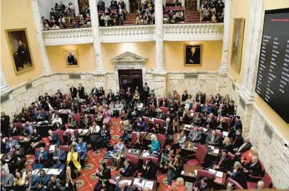  ?? BARBARA HADDOCK TAYLOR/BALTIMORE SUN ?? Senators and their families crowd the Senate floor Wednesday on the first day of the legislativ­e session at the State House in Annapolis.
