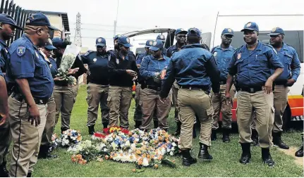  ?? /MDUDUZI NDZINGI ?? Members of the Johannesbu­rg metro police lay wreaths where their colleagues perished after an alleged drunk driver crashed into officers at a roadblock on Monday.