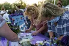  ?? John Roark/The Post-Register via AP ?? Visitors write notes for Tylee Ryan and Joshua “JJ” Vallow on Friday during a memorial service for them in Idaho Falls, Idaho.