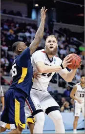  ?? Tony Avelar / The Associated Press ?? Gonzaga center Przemek Karnowski (right) is defended by West Virginia forward Elijah Macon during the first half of Thursday’s regional semifinal game.