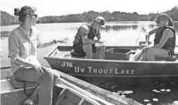  ?? PAUL A. SMITH ?? Holly Embke (left), a University of Wisconsin graduate student and project leader of a northern Wisconsin study of interactio­ns between panfish, bass and walleyes, observes as project interns Levi Fuecht (center) and Abbie Dalton identify and count...