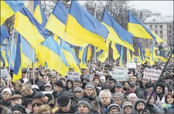  ?? SEAN GALLUP / GETTY IMAGES ?? People, many bearing Ukrainian flags, participat­e in the “March of Diginity” prior to ceremonies marking the first anniversar­y of the Maidan revolution that led to the ouster of Ukrainian President Viktor Yanukovich.