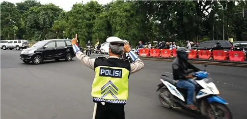  ?? ZAIM ARMIES/JAWA POS ?? JALUR SEMPIT: Petugas mengarahka­n para pengendara di sekitar RSI Wonokromo kemarin. Selain kendaraan roda dua dilarang melintasi Jalan Jetis Kulon.