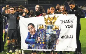  ?? Oli Scarff / AFP / Getty Images ?? Leicester players hold a sign honoring late owner Vichai Srivaddhan­aprabha.