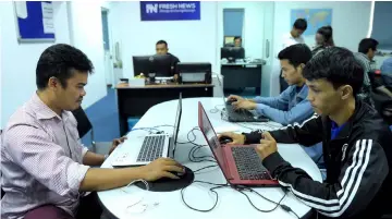  ??  ?? Cambodian online news outlet ‘Fresh News’ staff members working in their newsroom in Phnom Penh. — AFP photo