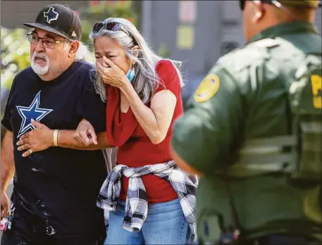  ?? William Luther / San Antonio Express-News ?? A woman cries Tuesday as she leaves the Uvalde Civic Center. At least 18 students and 3 adults were killed when a gunman opened fire at Robb Elementary School in Uvalde according to Texas Gov. Gregg Abbott.