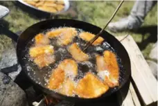  ??  ?? Cooking walleye for a local feast at Grassy Narrows First Nation in Ontario.