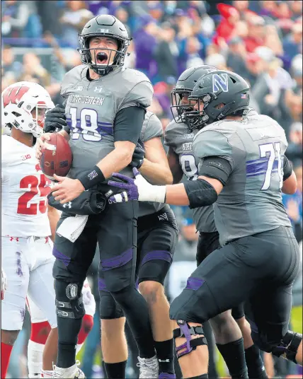  ?? JOHN J. KIM/CHICAGO TRIBUNE ?? Northweste­rn quarterbac­k Clayton Thorson, left, celebrates after scoring a touchdown in the second quarter against Wisconsin at Ryan Field in Evanston on Saturday.