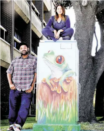  ?? Elizabeth Conley / Houston Chronicle ?? Studio owner Noah Quiles and artist Anat Ronen check out the second mural Ronen created on a utility box in the Westchase District after the first was painted over by a graffiti abatement worker.