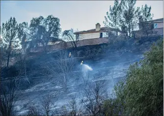  ?? Bobby Block/The Signal ?? Firefighte­rs stake out positions on a hillside along the northbound lanes of Interstate 5 to combat the Lake Hughes Fire, which scorched at least 10 acres Thursday afternoon.