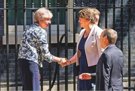  ?? AP ?? Britain’s Prime Minister Theresa May welcomes Democratic Unionist Party leader Arlene Foster and DUP deputy leader Nigel Dodds outside 10 Downing Street in London yesterday.