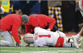  ?? PHOTOS BY GREGORY SHAMUS / GETTY IMAGES ?? Ohio State quarterbac­k Justin Fields injured his knee after a teammate rolled onto his left leg against Michigan last Saturday.