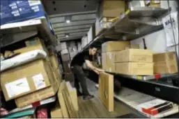  ?? MARK LENNIHAN — THE ASSOCIATED PRESS ?? A UPS employee loads packages onto a truck at a company facility in New York. With Christmas on a Monday, most retailers have one less day to get packages delivered on time. UPS said earlier in December that some package deliveries were being delayed...