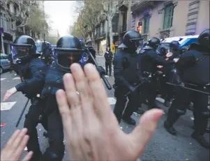  ?? AP PHOTO ?? Catalan Mossos d’Esquadra regional police officers clash with pro-independen­ce supporters trying to reach the Spanish government office in Barcelona, Spain, Sunday.