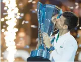  ?? MATTHEW STOCKMAN/GETTY ?? Novak Djokovic kisses the trophy after winning his recordtyin­g sixth ATP Finals title Sunday. Roger Federer also won the tournament six times.