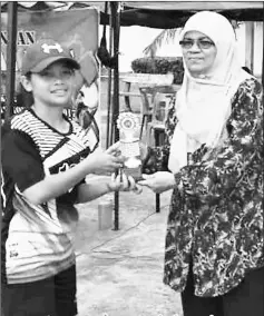  ??  ?? Saripah Azizah presents the ‘Best Girl Scorer Award’ to Kimberly Kijan.