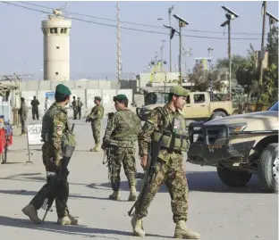  ??  ?? KABUL: Afghanista­n’s National Army soldiers guard, blocking the main road to the Bagram Airfield’s main gate in Bagram, north of Kabul, Afghanista­n yesterday. —AP