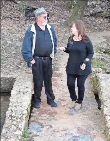  ?? Doug Walker / Rome News-Tribune ?? Cave Spring DDA board member Billy Wayne Abernathy (left) strolls across a rock bridge on a trail in Rolater Park with DDA Director Sandra Lindsey. The two were talking about plans for the upcoming Outdoor Adventure Day.