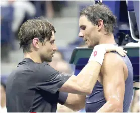  ?? AP FOTO ?? HANGING HIS RACKETS. David Ferrer retires by sharing the court with good friend and teammate Rafael Nadal for his last match.