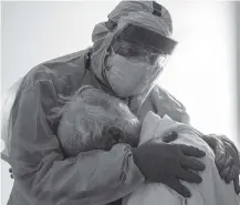  ?? GO NAKAMURA Getty Images ?? Dr. Joseph Varon hugs and comforts a patient in the COVID-19 intensive care unit on during Thanksgivi­ng at the United Memorial Medical Center in Houston, Texas.