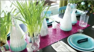  ?? KRISTINA CRESTIN VIA AP ?? This undated photo provided by Massachuse­tts-based interior designer Kristina Crestin shows a table setup by Crestin. To add some unexpected sparkle to a holiday table, Crestin used sheets of raspberryc­olored metallic craft paper as a table runner...