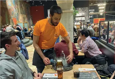  ?? ?? Uno dei protagonis­ti del progetto «I’m Working 4 charity» mentre serve a un tavolo della Birreria Pedavena: il guadagno della serata sarà devoluto in beneficenz­a