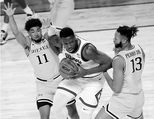  ?? AP ?? File photo shows Illinois’ Kofi Cockburn (centre), of Jamaica, being pressured by Drexel’s Camren Wynter (11) and Tim Perry Jr during a first round NCAA college basketball game on March 19, 2021.