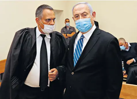  ??  ?? Benjamin Netanyahu, the Israeli prime minister, wearing a face mask as he stands inside Jerusalem district court as his corruption trial opens