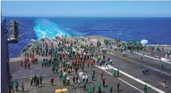  ?? NELVIN C. CEPEDA U-T ?? Off the coast of California, flight deck crew members walk the length of the Vinson’s flight deck Wednesday searching for foreign object debris.